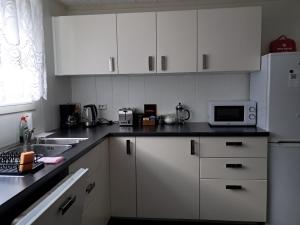 a kitchen with white cabinets and a white refrigerator at A peaceful and quiet apartment in Oltedal