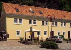 a yellow building with a car parked in front of it at Ferienwohnung Echtner in Bad Schandau