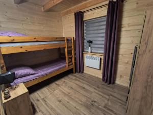a room with two bunk beds in a log cabin at Domek przy lesie na Roztoczu in AdamÃ³w