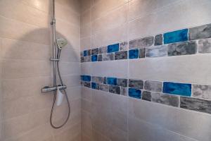 ein Badezimmer mit einer Dusche mit blauen Fliesen in der Unterkunft Le Rayon de Soleil in Saint-Georges-de-Didonne