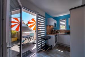 eine Küche mit blauen Wänden, einem Tisch und einem Stuhl in der Unterkunft Le Rayon de Soleil in Saint-Georges-de-Didonne