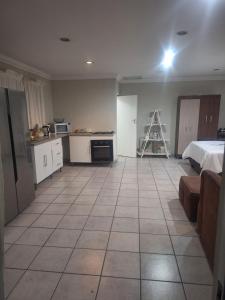 a large room with a kitchen and a bed at Bella Cottage Escape in Rooihuiskraal