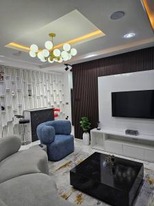 a living room with a television and a couch and chairs at Beach View Shortlet Apartment With Pool Ajah Lekki Lagos in Lagos
