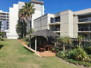a gazebo with a table in front of a building at Coastal Scarborough Beach Chic Pool View 2BR in Perth