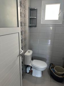 a small bathroom with a toilet and a window at Liliane Appartement in El Haouaria +10 photos