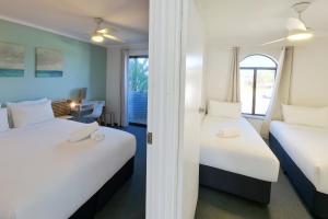 a hotel room with two beds and a window at Coastal Scarborough Beach Chic Pool View 2BR in Perth +32 photos