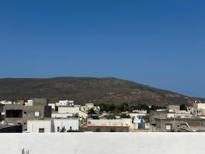 a view of a city with a mountain in the background at Liliane Appartement in El Haouaria
