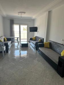 a living room with two couches and a television at Liliane Appartement in El Haouaria