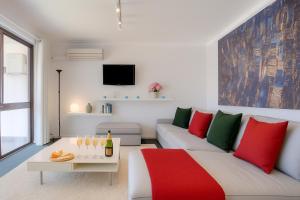 a living room with a white couch and red and green pillows at Coastal Scarborough Beach Chic Pool View 2BR in Perth