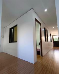 una camera con una parete bianca e un letto di Chill at Ohana Stay in Antipolo Rooftop Escape a Maagay Altre 6 foto