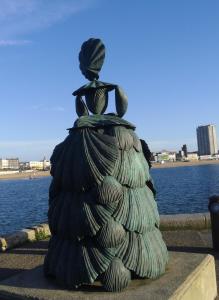 a statue of a woman sitting on top of a pile of trash at Andorinho Sea View Apartment in Margate