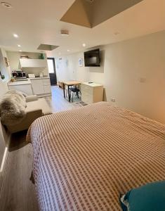 a bedroom with a bed and a desk and a kitchen at Katrins Nest in Southbourne