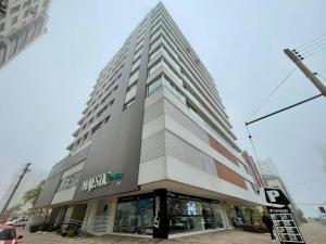 a tall building on the corner of a street at Apartamento Majestic Tower in Capão da Canoa