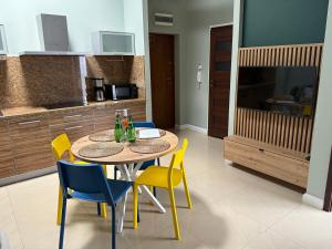 Una cocina con una mesa y sillas en una habitación. en Apartament Gardenia Sun, en Międzywodzie