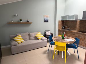 a living room with a couch and a table and chairs at Apartament Gardenia Sun in Międzywodzie