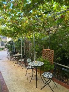 a group of tables and chairs under a pergola at La Strettoia in Caprioli