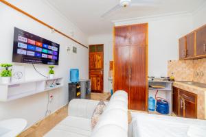 a living room with a white couch and a tv at Yunke Homes Comfortable Studio in Bamburi in Mombasa