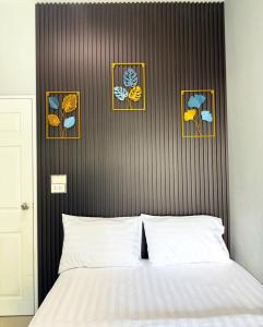 une chambre avec un lit avec trois tableaux au mur dans l'établissement House Near Hatyai City, 5-7pax, Free2Parking&Wi-Fi, à Hat Yai