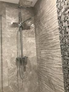 eine Dusche in einem Badezimmer mit einer Steinwand in der Unterkunft Modern Marina Apt Fantastic in Estepona