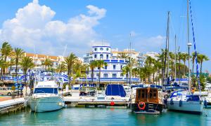 eine Gruppe von Booten, die in einem Yachthafen mit einem Gebäude angedockt sind in der Unterkunft Modern Marina Apt Fantastic in Estepona