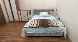 a bedroom with a bed in a room with wooden floors at Квартира в центре Бендер in Bender