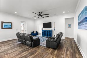 a living room with two chairs and a flat screen tv at Salty Seabass 4BR Seaside Escape in Port Bolivar