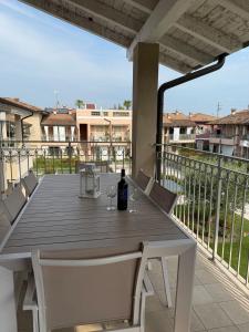 a wooden table with a bottle of wine on a balcony at Dream House Pool Garda Lake - Castelnuovo del Garda in Cavalcaselle