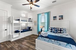 a bedroom with two bunk beds and a ceiling fan at Salty Seabass 4BR Seaside Escape in Port Bolivar