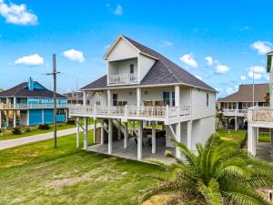 a white house with a porch and a yard at Salty Seabass 4BR Seaside Escape in Port Bolivar