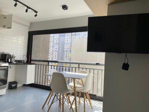 y cocina con mesa y sillas y balcón. en Flat na Liberdade próximo do Metrô, en São Paulo