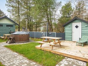 une arrière-cour avec une table de pique-nique et un bain à remous dans l'établissement 8 person holiday home in Hemmet, à Hemmet