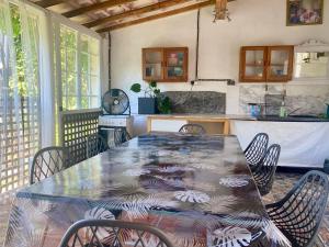a dining room table with chairs and a kitchen at Large Family Home in Mediterranean France in Tourbes
