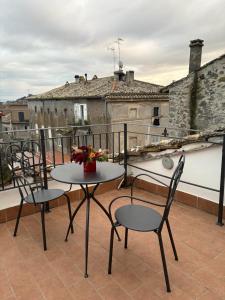 Un patio con una mesa y sillas en un balcón. en la giraffa bianca, en Vallerano