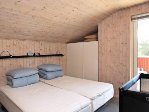 a bedroom with a bed in a wooden wall at 8 person holiday home in Hjørring-By Traum in Lønstrup +34 photos