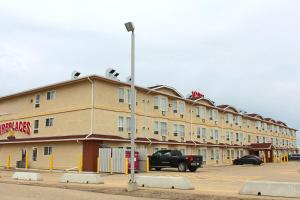 a large building with a truck parked in a parking lot at Western Budget Motel Ponoka in Ponoka