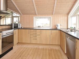 a large kitchen with wooden cabinets and a window at 5 star holiday home in Vestervig in Vestervig