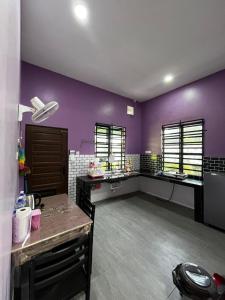 Un baño con paredes moradas y dos lavabos en una habitación. en AZZR Homestay, en Kuala Terengganu