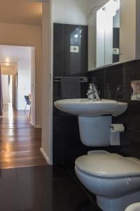 a bathroom with a sink and a toilet at Downtown Praia da Vitória AL in Praia da Vitória