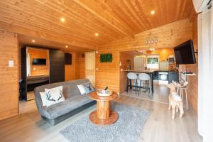 a living room with a couch and a table and a kitchen at Le Chalet des Pins avec Spa et Sauna in Sanchey