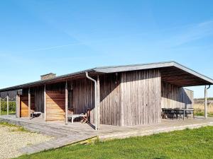 a wooden building with a deck in a field at 8 person holiday home in Vestervig-By Traum in Vestervig +26 photos