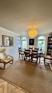 a living room with a table and chairs and a chandelier at Retro House by the Sea in Hollington