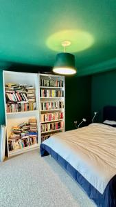 a bedroom with a bed and book shelves filled with books at Retro House by the Sea in Hollington
