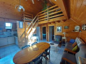 a living room with a wooden table in a cabin at La Petite Maison en bois climatisée sud de Sarlat in Vézac