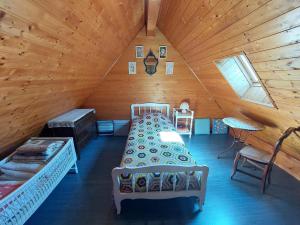 a room with two beds in a wooden attic at La Petite Maison en bois climatisée sud de Sarlat in Vézac