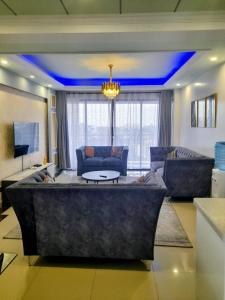 a large living room with a couch and a table at modern executive three bedroom apartment which features a swimming pool, state of the art fully equipped gym and all modern unmatched luxurious facilities which offfers luxury lifestyle in Nairobi