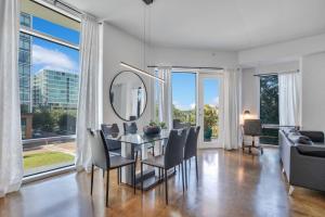 a dining room with a table and chairs and a mirror at 3 bedroom Corner Suite in Orlando