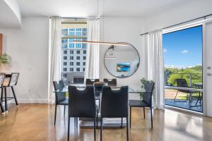 a dining room with a table and chairs and a mirror at 3 bedroom Corner Suite in Orlando