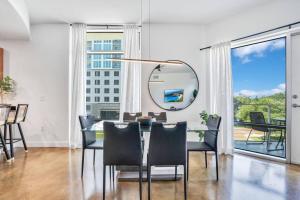 a dining room with a table and chairs and a mirror at 3 bedroom Corner Suite in Orlando