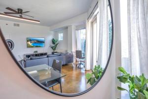 a living room with a table in a mirror at 3 bedroom Corner Suite in Orlando +37 photos