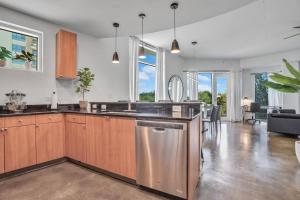 - une cuisine avec des placards en bois et un lave-vaisselle en acier inoxydable dans l'établissement 3 bedroom Corner Suite, à Orlando